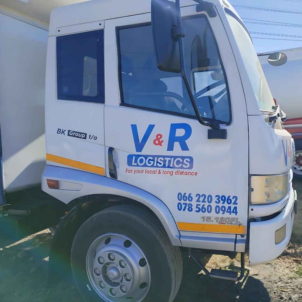 White V&R Logistics commercial delivery truck, branded for local and long-distance transport services, showing contact details.
